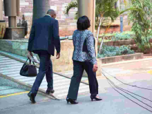 Kenyans Online React to Photo of Gender CS Sicily Kariuki's Bodyguard Carrying Her Handbag